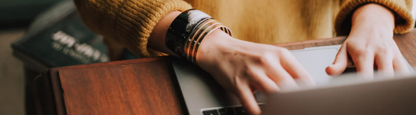 Hands typing on laptop keyboard